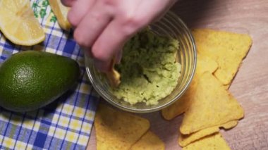 Aile geleneksel Meksika guacamole sosunu cips ile yer. Sağlıksız ve sağlıklı yiyeceklerden vejetaryen atıştırmalığı.