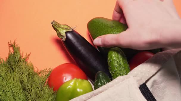Le concept de vie sans gaspillage. Les mains sortent de beaux légumes frais d'un sac en coton après les courses au marché. Gros plan statique — Video