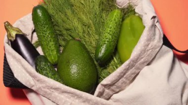 Eller şeftali arka planında pamuk torbadaki tüm sebzeleri ayırır, izole eder. Plastik yerine ekolojik şeyler kullanmak, çevresel bakım kavramı ve en az atık