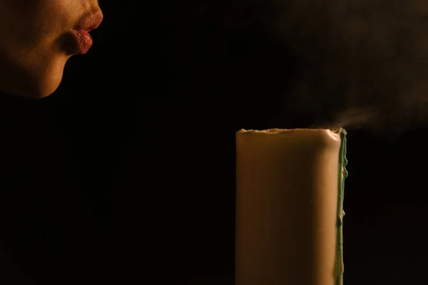 Sesión espiritual: una mujer apaga una vela encendida. Fondo aislado y negro. El concepto de religión, fe, magia y brujería —  Fotos de Stock