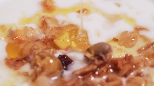 Macro shot - gota de miel de montaña para granola y yogur. El concepto de una dieta saludable, fitness — Vídeo de stock