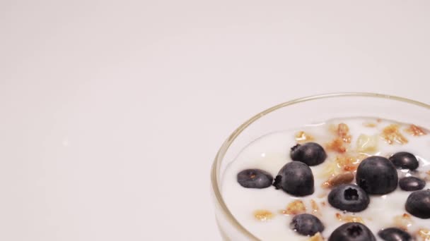 Granola sain avec yaourt sans gluten. Fille prend une cuillerée de yaourt et quelques bleuets — Video