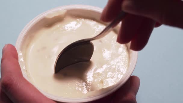 Woman eating gluten free yogurt with a spoon. Female hands pick up a cottage cheese with a spoon, isolated on a white background — Αρχείο Βίντεο