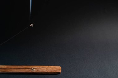 Aromatik çubuk koyu bir arka planda yanmış. Metnin için kopyalama alanı