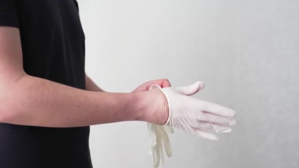 COVID-19 kavramı. Tıbbi beyaz eldiven giyen bir adam. Karantina sırasında koronavirüsten korunma. Halka açık bir yerde enfeksiyon kapma korkusu. Doktor virolog hastanede ellerini koruyor. — Stok video