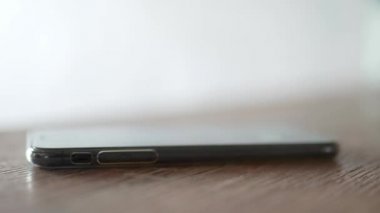 Beyaz tıbbi eldivenli biri koronavirüs salgını sırasında masadan çalan bir telefonu alır. Covid-19 'dan savunma