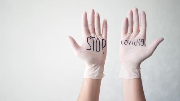 Stop covid-19 text on white medical gloves. A protective agent against coronavirus during a pandemic — Stock Video