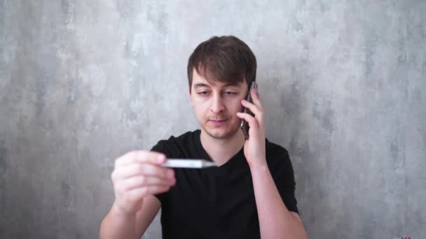 Un jeune homme discute avec le médecin au téléphone de ses symptômes de la maladie. Homme malsain avec une forte fièvre — Video