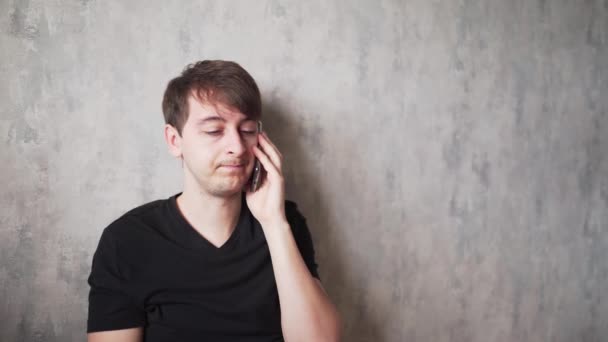 Mladý muž s bolestí hlavy mluví po telefonu. Nemocný doma v karanténě — Stock video