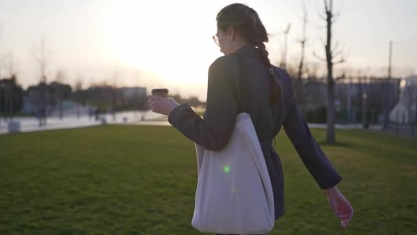 Una mujer atractiva con una bolsa de algodón en un traje al atardecer. El concepto de un estilo de vida saludable sin residuos plásticos — Vídeos de Stock