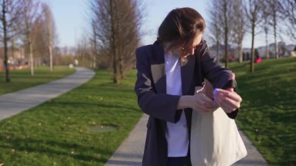 De zakenvrouw haalt de groene appel uit de katoenen zak. Lunchpauze in het park, veganistische levensstijl — Stockvideo