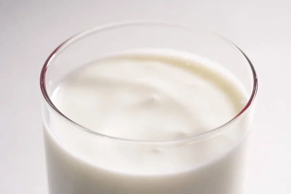 Glas verse vegetarische yoghurt op kokosmelk. Eco melk in een transparant glas op een witte achtergrond, geïsoleerd — Stockfoto