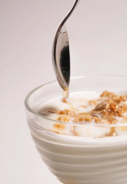 Hausgemachtes Frühstück mit Milch, Gelee und Honig. Löffel über einem transparenten Glas auf weißem Hintergrund — Stockfoto
