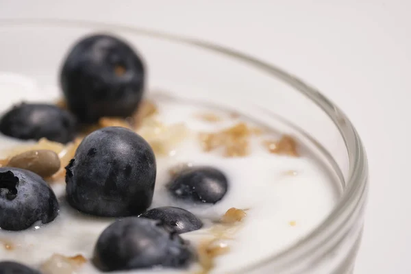 Blaubeeren in veganem Joghurt im durchsichtigen Glas, gesundes Frühstück. Fügen Sie die beerenförmigen Vitamine zum Milchdessert hinzu. Nahaufnahme — Stockfoto