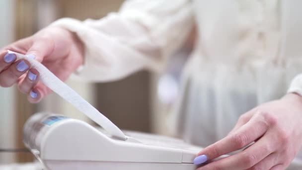 The seller rips off and checks the check and gives the buyer a close-up. White cash register close-up — Stock Video