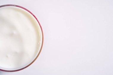 Şeffaf bardakta taze organik yoğurt. Yarısı güzel süt yoğurdu, beyaz arka plandaki metnin için kopyalama alanı