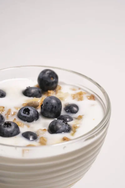 Frische Blaubeeren zum gesunden Frühstück in ein Glas mit Joghurt. Konzept der richtigen Ernährung und gesunden Lebensweise — Stockfoto