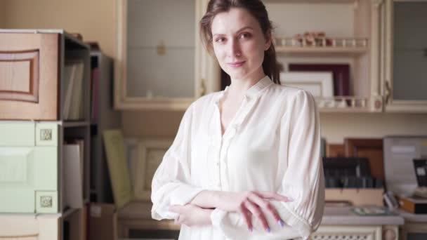Porträt einer schönen jungen Verkäuferin in einem Möbelhaus. Der Glücksmanager blickt in die Kamera — Stockvideo