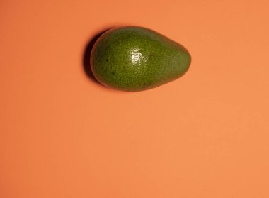 Şeftali arkaplanda olgun yeşil bir avokado, yukarıdan bir manzara.