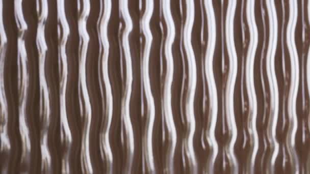 Fénysugár mozog a felületi textúra mentén. Volumetrikus textúra hullámok egy barna sima háttér felületen — Stock videók