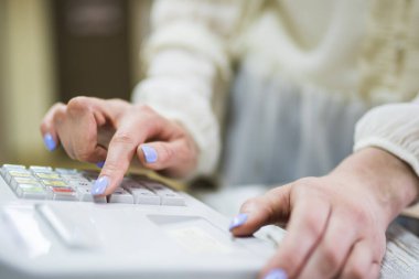 Dükkandaki kasiyer kasaya gelir ve hesabı öder. Mobilya ofisinde yakın plan satış elemanı.