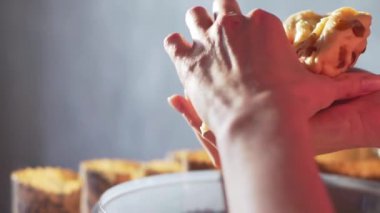 Kadın bitmiş hamuru kuru üzümle çıkarır ve yavaşça kırar. Evde yemek pişirmek, doğal biyolojik hamurlar.