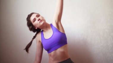 Genç bir sporcu kadın karantina ve koronavirüs sırasında çevrimiçi eğitim alıyor. Kız, antrenörden sonra internetten egzersiz ve tekrara bakar.