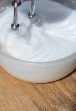 Fırıncı yumurta beyazlarını karıştırıcıyla karıştırır. Paskalya için tatlı hazırlıyorum.