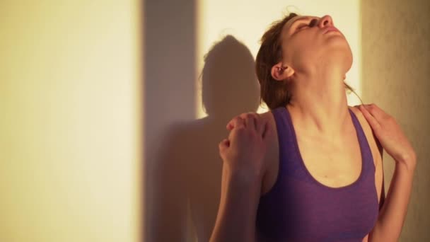 Une jeune femme étire son cou au coucher du soleil ou à l'aube. Exercice pour la santé et le bien-être — Video