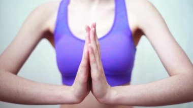 Nilüfer pozisyonunda kadın ellerini kenetleyin. Karantina ve salgın sırasında evde yoga yap.