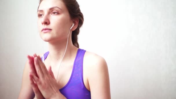 Йога слухає мелодію під час медитації. Складання рук і дихання в позі асан — стокове відео