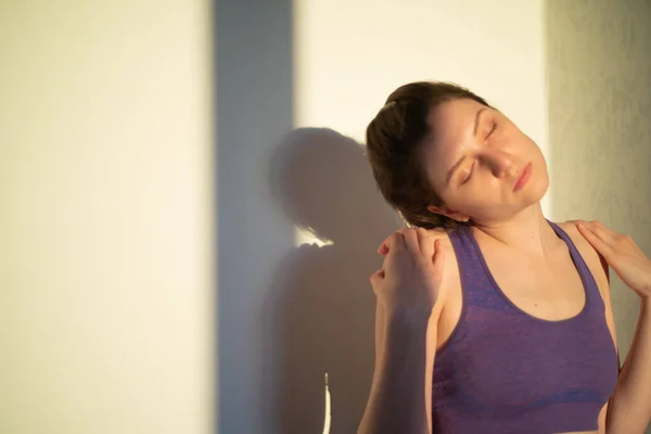 Молодая женщина растягивает шею на закате или на рассвете. Упражнения для здоровья и благополучия — стоковое фото