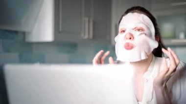 İş sırasında, bir kadın spa yapar ve yüzüne nemlendirici bir maske takar. Cilt bakımı yap. Cilt yenilenmesi için kozmetik prosedürleri.