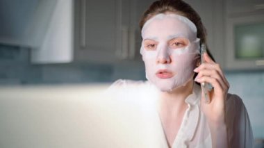 Tembel serbest çalışan kız. Evde çalışan serbest çalışan biri telefondaki problemleri yüzünde nemlendirici bir maskeyle çözer.