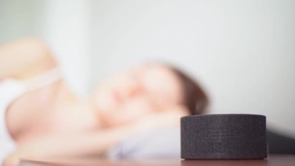 Mladá žena spí na pozadí chytrého řečníka. Speciální aplikace, které vám pomohou ponořit se do spánku — Stock video