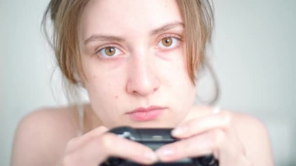 Adicción al juego. Una jugadora femenina se enfrenta con un primer plano de dependencia del juego cuando juega un jostik de consola frente al televisor — Vídeos de Stock