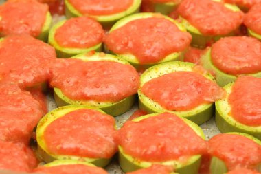 Pişirme önce domates sosu ile tepesinde kabak dilimlenmiş