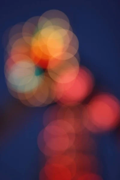 Blue, red, yellow, blue, white blurred festive bokeh background with stars for Christmas