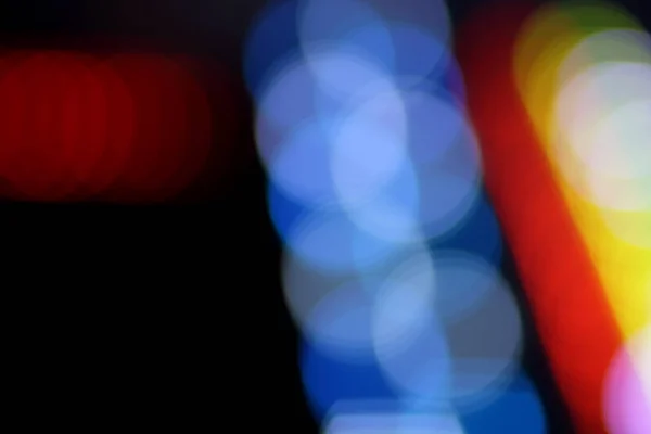 Blue, red, yellow, blue, white blurred festive bokeh background with stars for Christmas