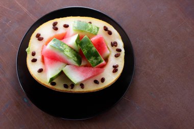 Siyah bir plaka üzerinde karpuz kavun dolması