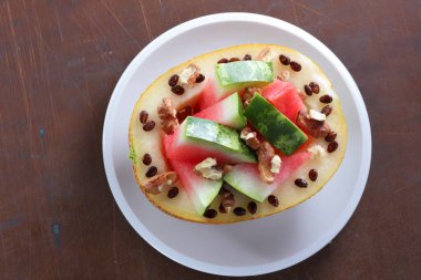 Beyaz bir plaka üzerinde ceviz serpilir karpuz, kavun dolması