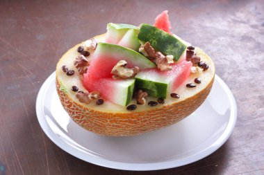 Beyaz bir plaka üzerinde ceviz serpilir karpuz, kavun dolması