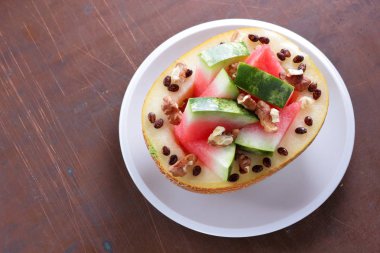 Beyaz bir plaka üzerinde ceviz serpilir karpuz, kavun dolması