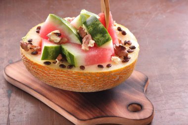 Bir ahşap tahta üzerinde ceviz serpilir karpuz, kavun dolması