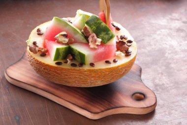 Bir ahşap tahta üzerinde ceviz serpilir karpuz, kavun dolması