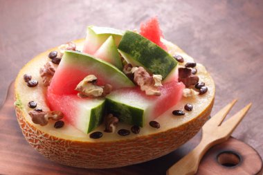 Bir ahşap tahta üzerinde ceviz serpilir karpuz, kavun dolması