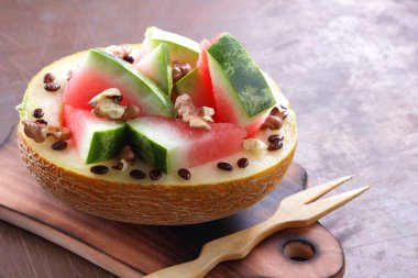 Bir ahşap tahta üzerinde ceviz serpilir karpuz, kavun dolması