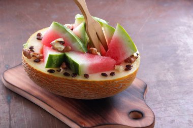 Bir ahşap tahta üzerinde ceviz serpilir karpuz, kavun dolması