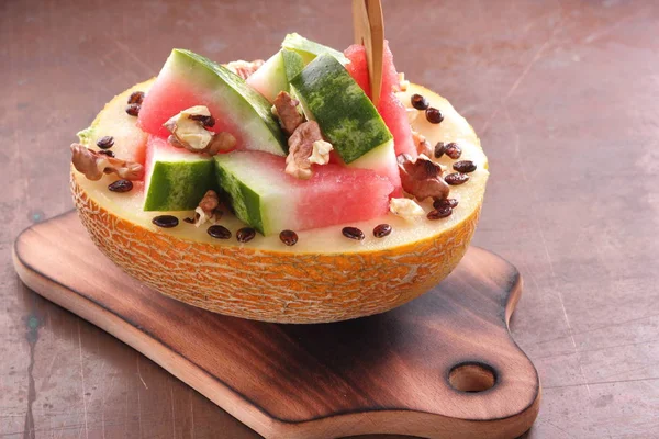 Bir ahşap tahta üzerinde ceviz serpilir karpuz, kavun dolması