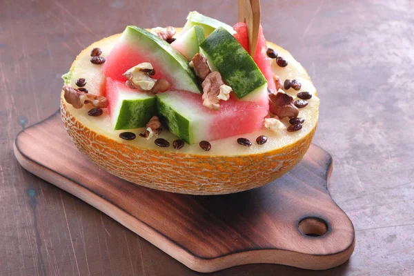Bir ahşap tahta üzerinde ceviz serpilir karpuz, kavun dolması
